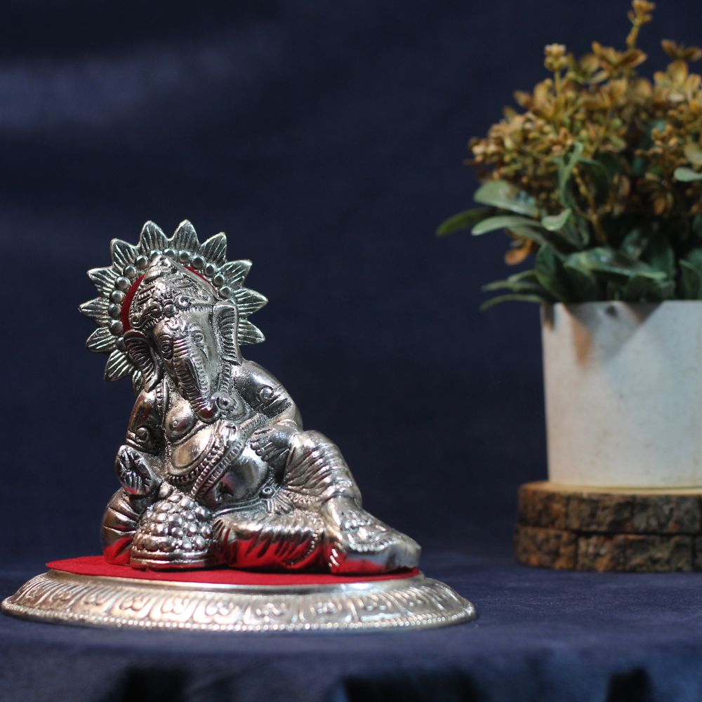 Reclining Ganesha Idol – Silver Finish — Silver tone on a red fabric base