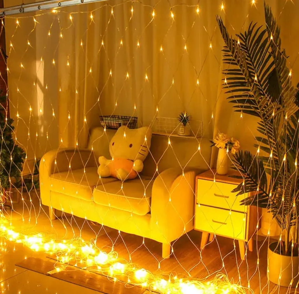 LED mesh net curtain lights draped over garden shrubs