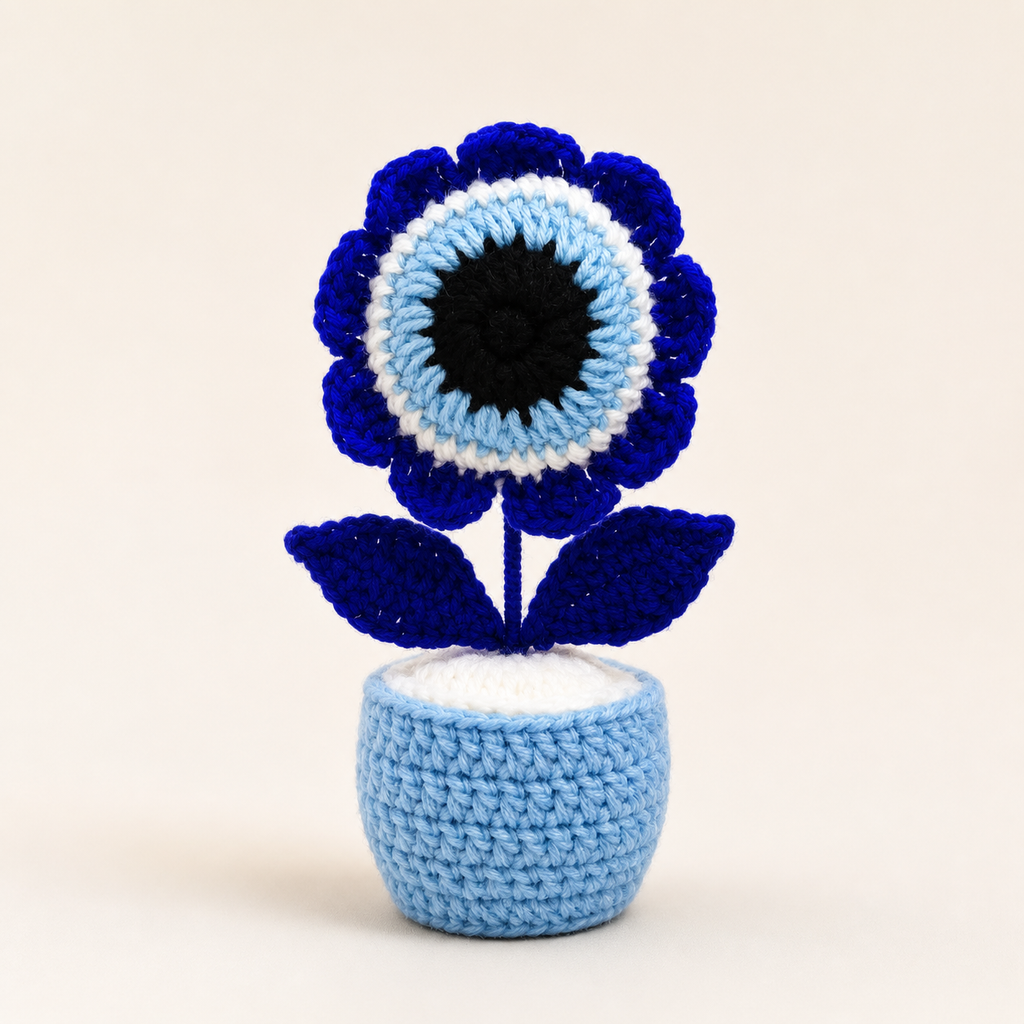 Front view of crochet evil eye flower pot in blue, white and black
