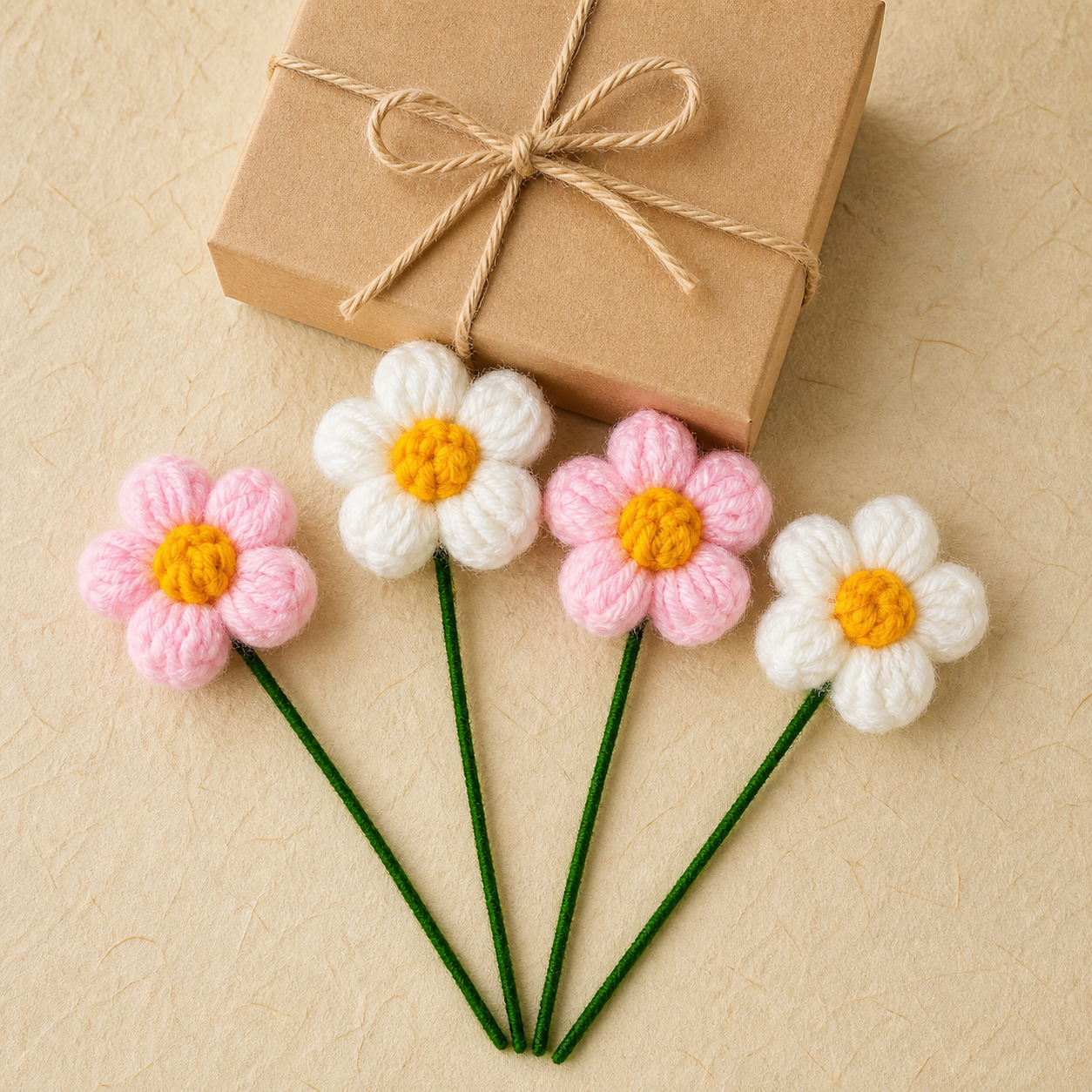 Crochet puff flower set of four displayed beside a gift box