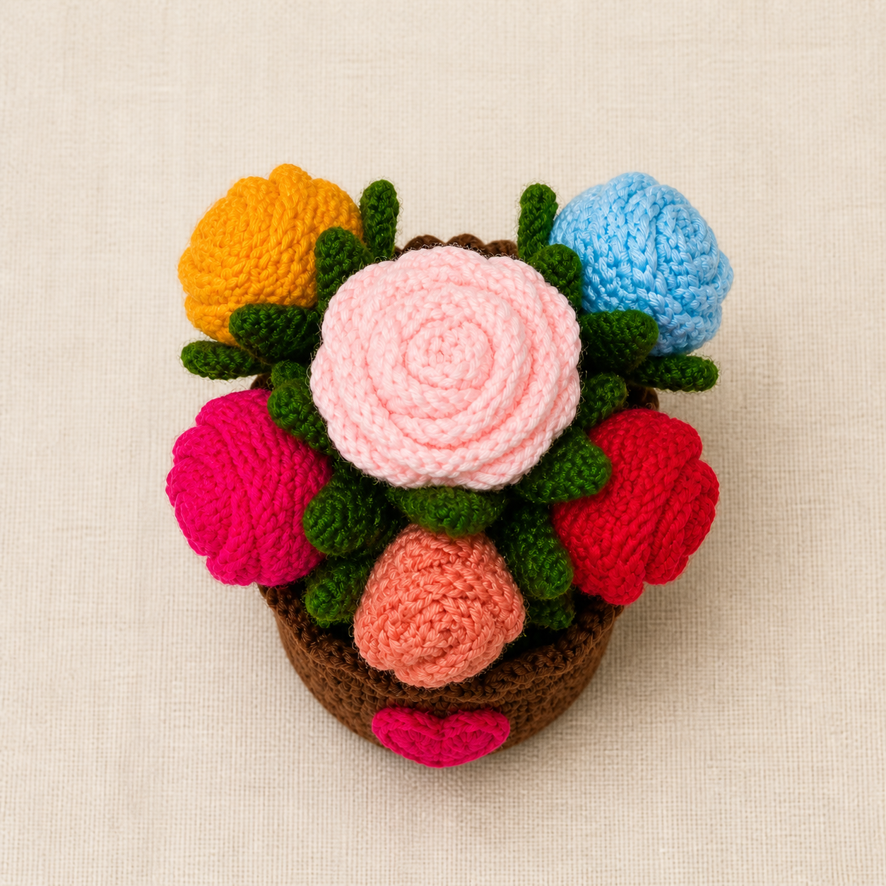 Top view of colourful crochet roses in yellow, blue, red, pink, light pink and peach