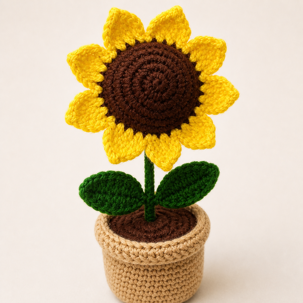 Close-up of handmade crochet sunflower petals, leaves and pot stitching