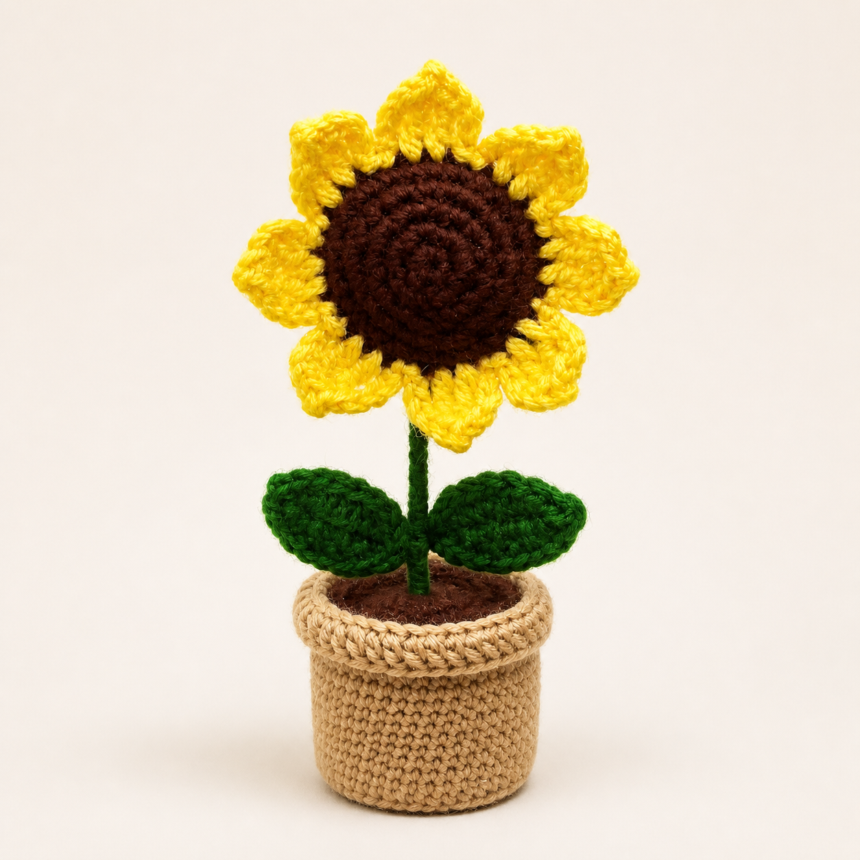 Handcrafted crochet sunflower with yellow petals, brown centre, green leaves and tan pot