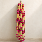 6 ft cream and magenta artificial flower garland hanging on a warm ivory wall