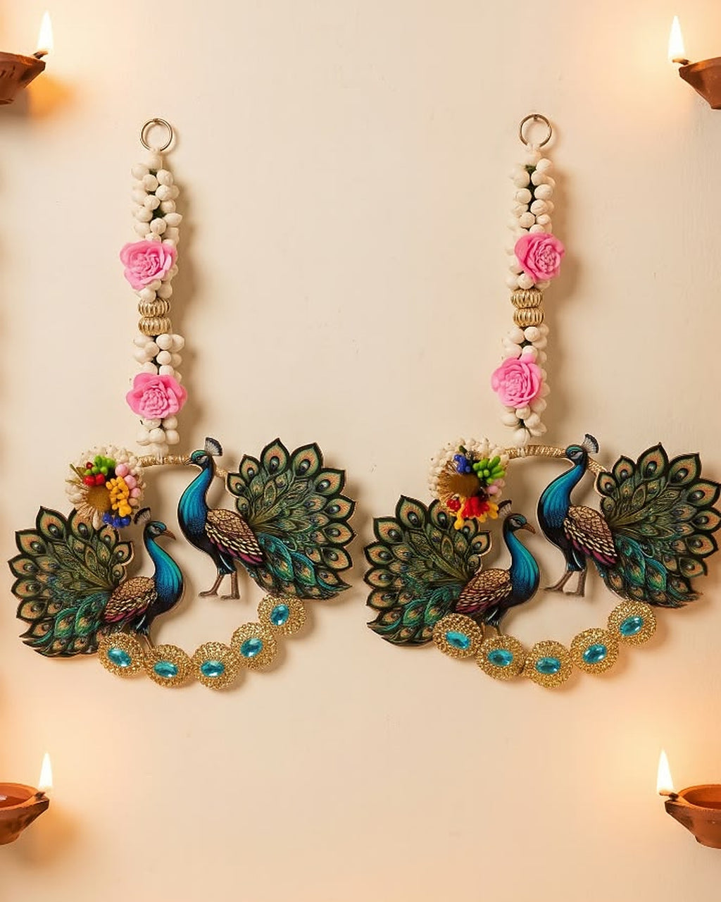 Peacock wall hanging pair on a festive wall with diyas and marigold garland