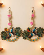 Peacock wall hanging pair on a festive wall with diyas and marigold garland