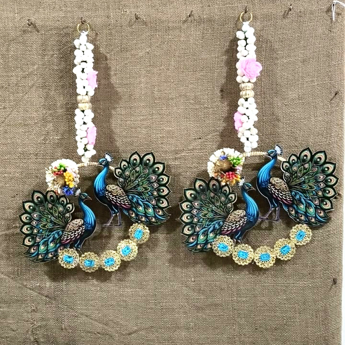 Peacock wall hanging pair hung side by side on a wall