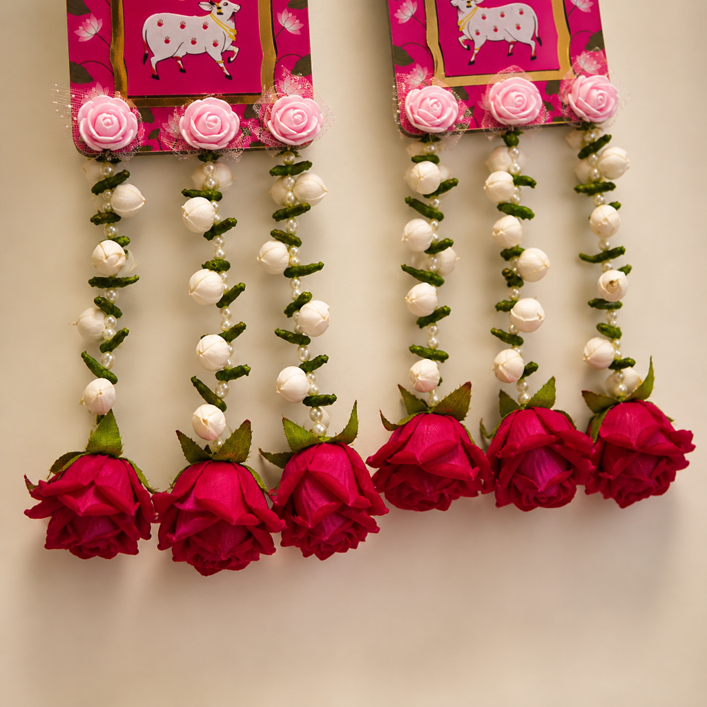 Close-up of white floral strands and deep red rose tassels on the red Shubh Labh hangings