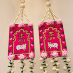 Close-up of red Shubh and Labh panels with lotus, cow motifs and pink rose accents