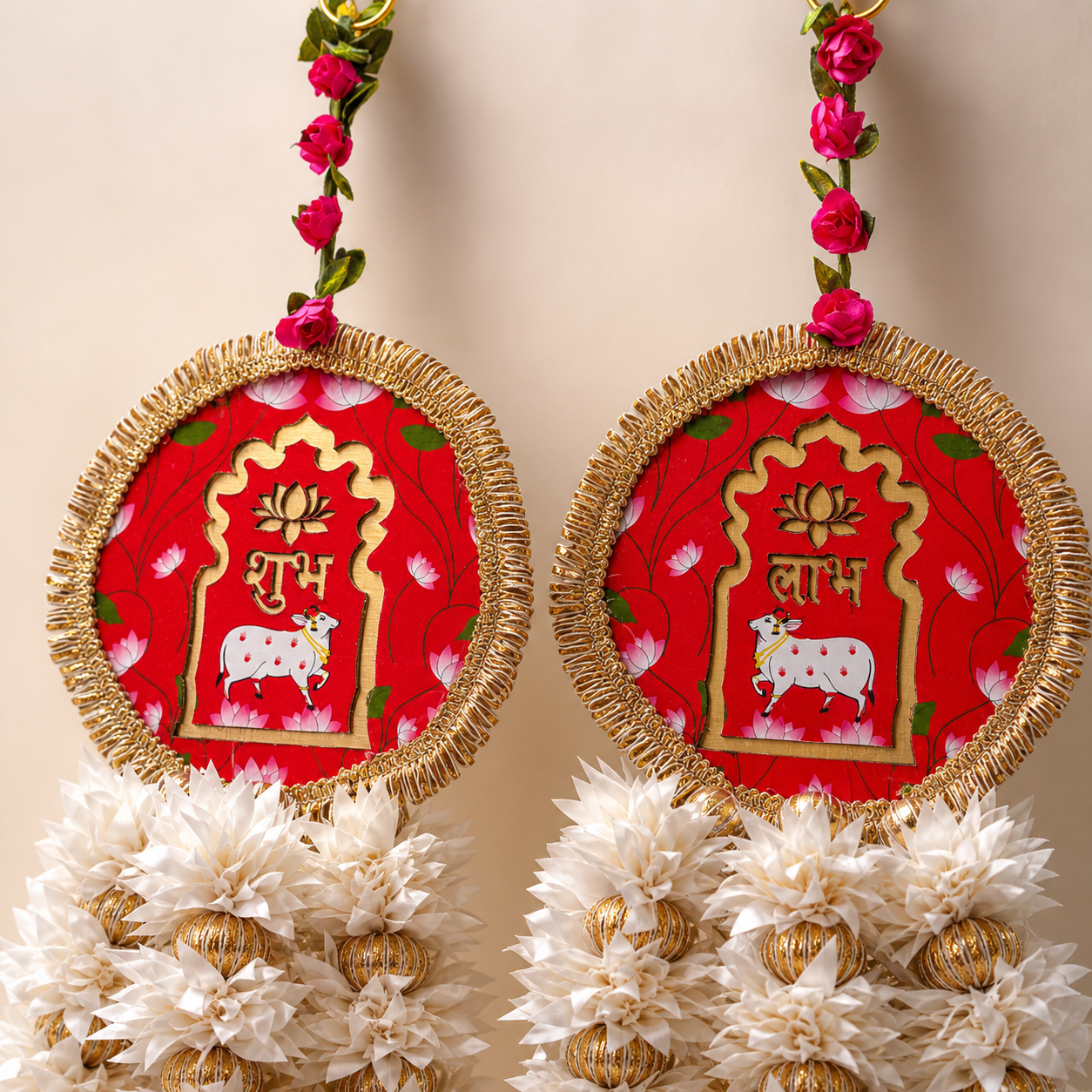 Close-up of round red Shubh and Labh panels with lotus and cow motifs and gold trim
