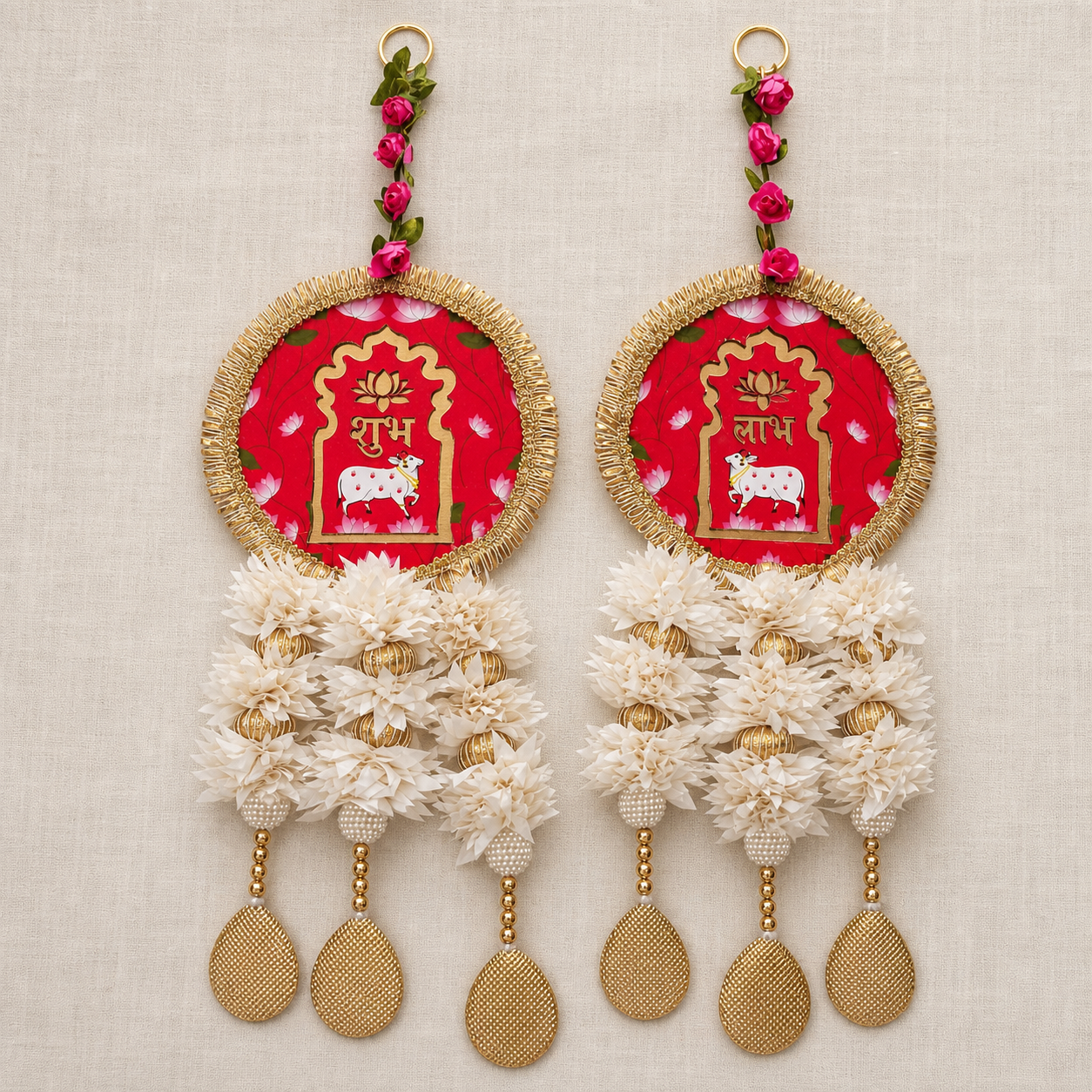 Full view of the red and white floral Shubh Labh hanging pair on a neutral fabric background