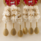 Close-up of white floral clusters, pearl-style beads and textured gold drops
