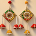 Close-up of Shubh Labh metal filigree panels, pearl embellishments and silk jhumkas