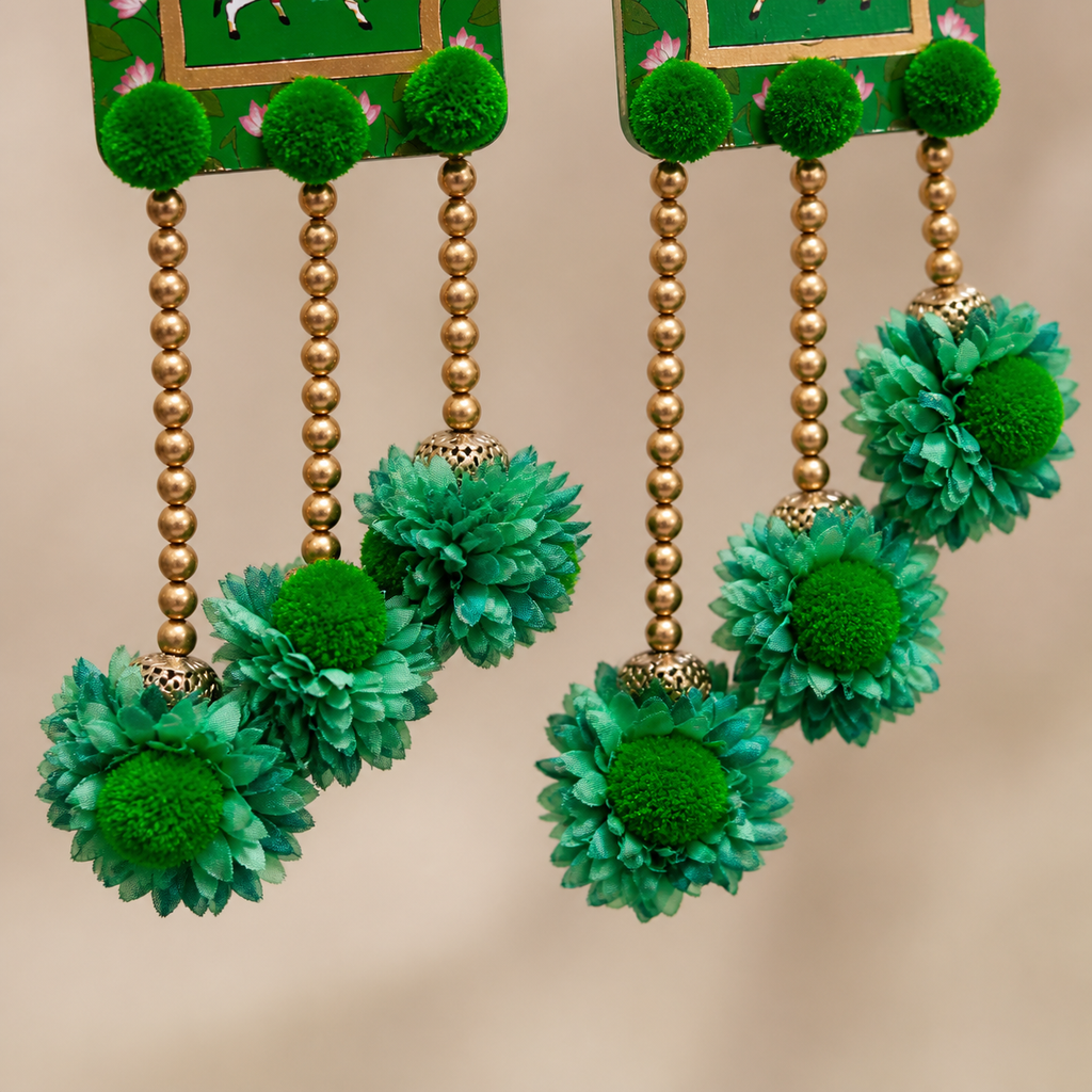 Close-up of green fabric flowers and gold-coloured beads on the Shubh Labh toran