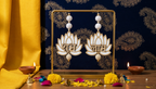 White and gold Shubh Labh lotus door hanging pair styled with diyas and marigolds